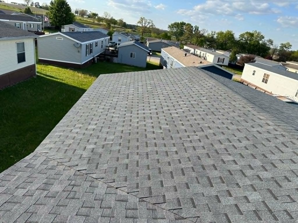 Newly repaired roof with clean shingle lines under natural daylight.